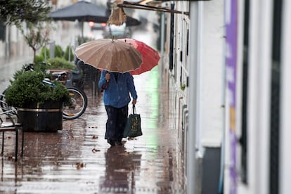 Dos personas caminan bajo la lluvia en Sant Lluís, Menorca, el pasado sábado.