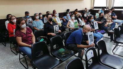 Los familiares de las víctimas del Diario Militar muestran retratos con las caras de los desaparecidos durante la audiencia de este viernes.