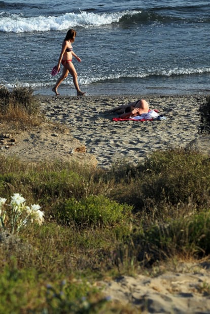 Bañistas en la parte textil de la playa de Cabopino, en Marbella.