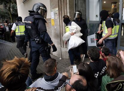 A polícia leva as urnas de uma mesa de votação em Barcelona.