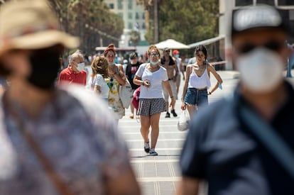 Personas sin mascarilla y con mascarillas en el paseo marítimo de la playa Malvarrosa de Valencia.