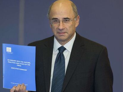 Lord Brian Leveson posa con el informe.
