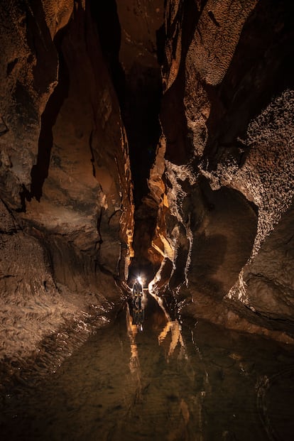 Un espeleólogo en un pasadizo dentro de la cueva de Coventosa, Cantabria.