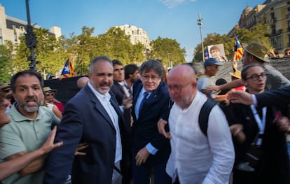 El líder independentista y 'expresident' de Cataluña Carles Puigdemont, en el centro, llega con su abogado, Gonzalo Boye, al paseo Lluís Companys de Barcelona para dirigirse a su militancia.