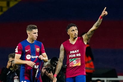 Raphinha (derecha), celebra el segundo gol del equipo blaugrana con una camiseta en recuerdo a los afectados por las inundaciones en Río Grande del Sur (Brasil).
