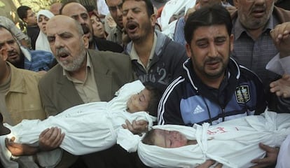 Palestinos sostienen los cad&aacute;veres de dos ni&ntilde;os durante su funeral.