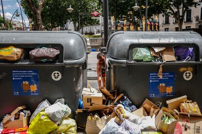 Un joven deja basura entre los contenedores de reciclaje en la plaza de Tirso de Molina de Madrid.