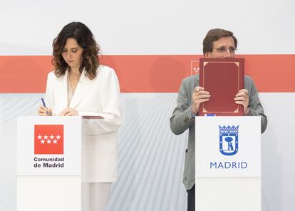 La presidenta de la Comunidad de Madrid, Isabel Díaz Ayuso y el alcalde de Madrid, José Luis Martínez-Almeida, durante la firma de un convenio de colaboración, en la Real Casa de Correos, este viernes.