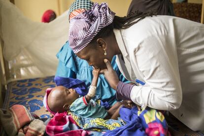 Mariama Aboubacar es la psicóloga del CRENI de Mayahí. Vital, alegre, entregada, se encarga de atender los problemas motores, de humor o de lenguaje de los pequeños, a los que intenta estimular para acelerar su recuperación. En la imagen atiende a la pequeña Habsou Maman que llegó cuatro días atrás al centro en estado de inconsciencia. La niña, de 11 meses, presenta un grave retraso motor y es incapaz siquiera de sentarse. Su madre, Nana Mariama Tanco, dejó de darle el pecho bruscamente cuando supo que estaba embarazada de su decimotercer bebé. 