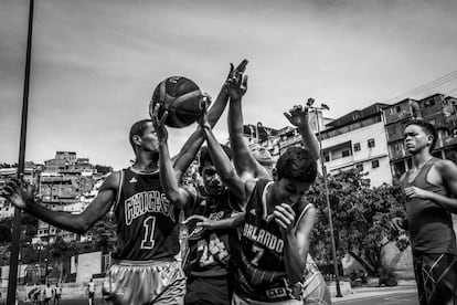 Un grupo de jóvenes juega al baloncesto en el campo de deportes en Mesuca, que se encuentra en el corazón de Petare. Hace varios años, el partido opositor ELMUD estableció el programa social 'El deporte salva vida' para disuadir a los jóvenes de caer en una vida delictiva.