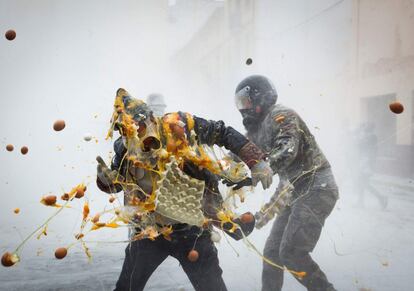 Batalla de 'Els Enfarinats' (los cubiertos de harina) para celebrar el Día de los Inocentes. En la tradicional fiesta alicantina, los participantes se visten con ropas militares y simulan golpes de estado mientras luchan con harina, huevos y petardos, frente al Ayuntamiento de Ibi.