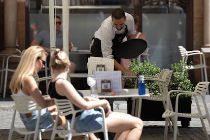 Un camarero trabaja en la terraza de un bar de Sevilla.