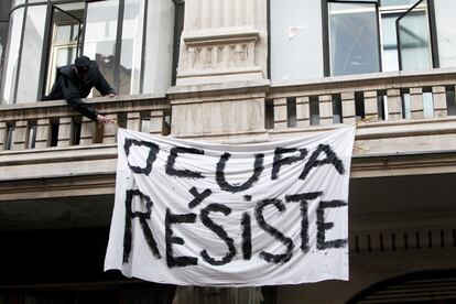 Un policía retira una pancarta de la fachada del hotel Madrid.