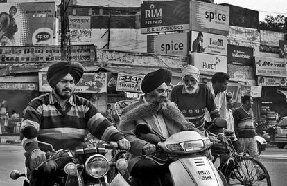 Una pareja de motoristas comparte espacio con ciclistas y peatones en una calle de Patiala, una ciudad del estado de Punjab, en el norte de India. El uso del casco es obligatorio para los motoristas aunque según la OMS en su informe global Road Safety 2015, destaca que las leyes indias en este sentido son aún deficientes. 