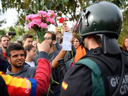 Manifestantes ofrecen claveles a un miembro de la Guardia Civil en Sant Juli&aacute;, el pasado 1 de octubre.