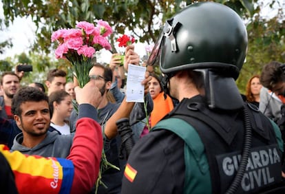 Manifestantes ofrecen claveles a un miembro de la Guardia Civil en Sant Juli&aacute;, el pasado 1 de octubre.