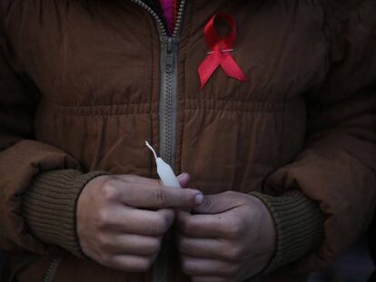 Mulher carrega o símbolo da luta contra a AIDS no mundo, em um centro de reabilitação de vítimas de tráfico sexual no Nepal.