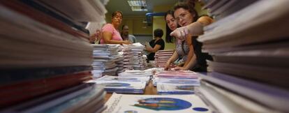 Varias madres preparan lotes de libros de la cooperativa escolar del colegio público Asturias, en Madrid.