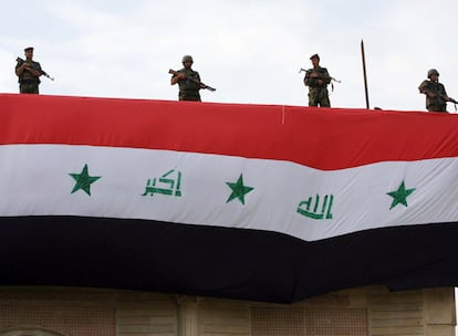 Soldados iraquíes han tomado posiciones en uno de los tejados del aeropuerto de Basora, presidido por una gran bandera de Irak, minutos antes de celebrarse el acto de transferencia de poderes.