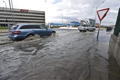 Varios vehiculos circulan entre una balsa de agua a la salida del aeropuerto de Málaga.