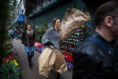 Pedestrians walk past plants displayed for sale in Manhattan's flower district in New York, U.S., on Thursday, March 24, 2016. With an El Nino in the equatorial Pacific, winter across the contiguous U.S. was the warmest in history, and new daily high temperatures were posted last week in Philadelphia, Trenton, Boston and New York's Central Park. Photographer: Michael Nagle/Bloomberg