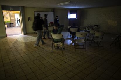 Un grupo de inmigrantes miran una película en el salón de la Casa del Migrante en Tijuana.