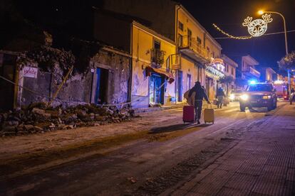 Un hombre porta lo que queda de sus pertenencias tras pasar junto a su casa derrumbada en Sicilia (Italia). Un terremoto provocado por el volcán Etna sacudió Sicilia la madrugada del martes,
