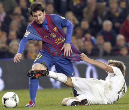 Messi intenta zafarse de Coentrão durante el partido Barça-Madrid del miércoles.