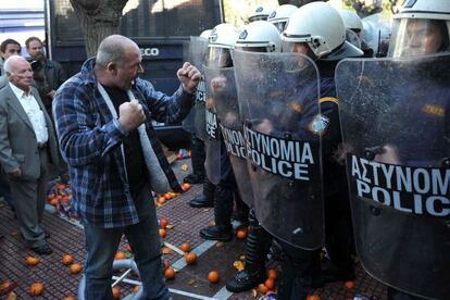 Un agricultor se encara con la policía en una protesta frente al Parlamento.