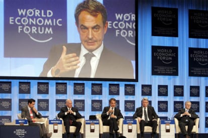 De izquierda a derecha, el moderador del debate, Robin Miblett; el primer ministro de Grecia, Giorgos Papandreu; el presidente del Gobierno español, José Luis Rodríguez Zapatero (en la pantalla); el presidente de Letonia, Valdis Zatlers, y el del BCE, Jean-Claude Trichet, ayer en el Foro de Davos.