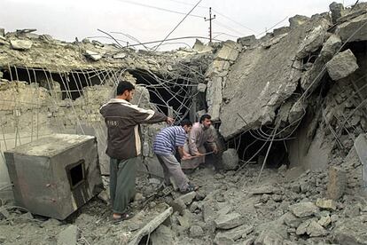 Los bombardeos de la aviación americana previos al asalto han destruido edificios y viviendas en la ciudad de Faluya. en la imagen tres iraquíes buscan entre los escombros de una casa.