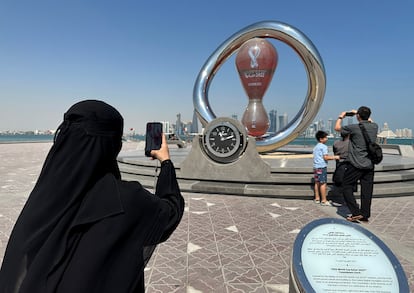 Una mujer toma una fotografía ante el reloj de la cuenta atrás para el inicio del Mundial de Qatar. 