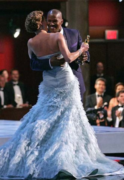 Jamie Foxx abraza a Charlize Theron tras recoger el Oscar al mejor actor protagonista por <i>Ray.</i>