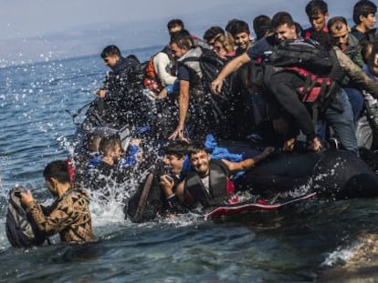 Migrantes saltan de una lancha neum&aacute;tica tras lograr alcanzar la costa cerca de Skala Sikaminias, en la isla griega de Lesbos.