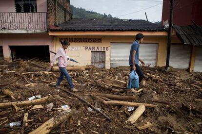 Dos vecinos de El Para&iacute;so, una comunidad de Guerrero, caminan sobre los escombros de una calle sepultada por el temporal.