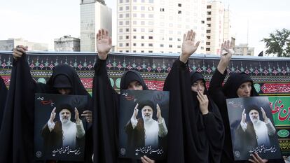 Iranian women hold portraits of the late president Ebrahim Raisi at a mourning ceremony in Tehran, on May 20, 2024.
