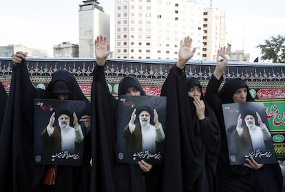 Mujeres iraníes partidarias del régimen sostienen retratos del fallecido presidente Ebrahim Raísi, en una ceremonia de duelo en Teherán, el 20 de mayo de 2024.