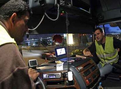 Dos de los camioneros participantes en la protesta de los transportistas charlan en el interior de su vehículo.