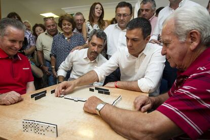 El líder del PSOE y candidato a la presidencia del Gobierno, Pedro Sanchez (c), durante una partida de dominó que ha jugado con los mayores del Centro de Participacion Activa de Anica Torres de Benalmádena (Málaga), junto al alcalde de dicho municipio, Víctor Navas (i).