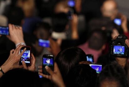 Un grupo de personas graba vídeos con sus móviles.