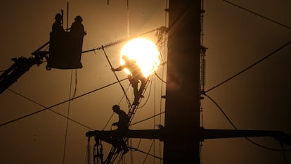 Trabajadores dan mantenimiento a cables de alta tensión en Santiago (Chile), en 2020.
