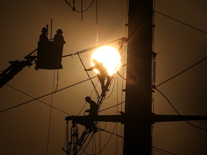 Trabajadores dan mantenimiento a cables de alta tensión en Santiago (Chile), en 2020.