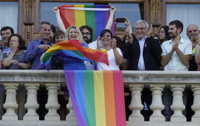El colectivo LGTB despliega su bandera en el balcón del Ayuntamiento de Valencia.