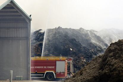 Los bomberos echan agua en la montaña de residuos procedentes del compostaje de los invernaderos de El Ejido.