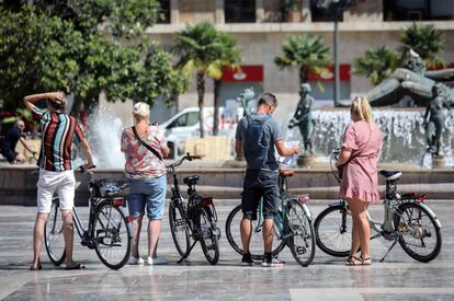 Un grupo de turistas recorre la plaza de la virgen este miércoles en Valencia, en un verano inusual debido a la pandemia, que ha hecho que se reduzca el número de visitantes en la ciudad.