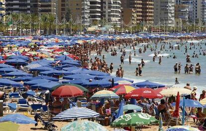 Miles de turistas en la playa de Benidorm.