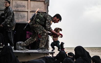 Un soldado de las Fuerzas Democráticas Sirias (SDF) ayuda a evacuar civiles de la asediada Baghouz, durante una operación para expulsar a los yihadistas del área, en la provincia oriental siria de Deir Ezzor.