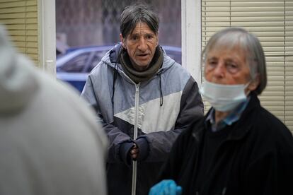 Joaquín, un hombre sin hogar de 51 años, espera a recibir su desayuno ante Fuensanta en el Comedor Solidario de Torrejón de Ardoz