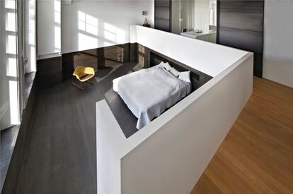 Como el salón-comedor, también el dormitorio principal tiene doble altura. La cama es de Hästens, y el pavimento, de roble. La mecedora es una versión de las Eames Plastic Chairs (Vitra).