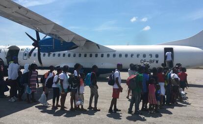 Vecinos evacuados en un avión, en el aeropuerto de Treasure Cay.